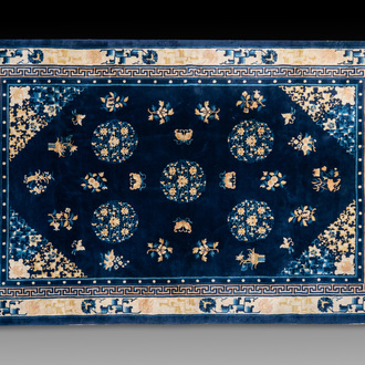Een groot Chinees donkerblauw tapijt met bloemen en vlinders, 19/20e eeuw