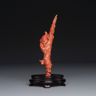 A Chinese red coral figure of a fisherman on wooden stand, 19/20th C.