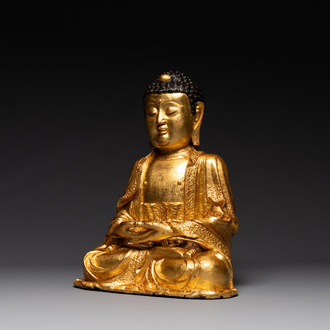 A large Sino-Tibetan gilt bronze Buddha on wooden stand, Ming