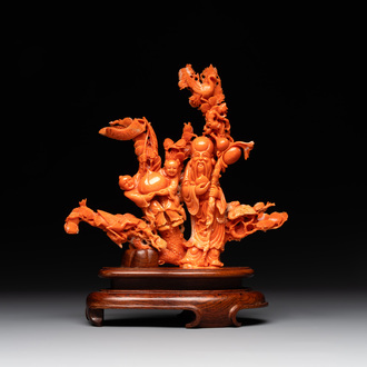 A Chinese red coral group of Shoulao with two boys holding a peach, inscribed 'Shou Bi Nan Shan 壽比南山', 19/20th C.