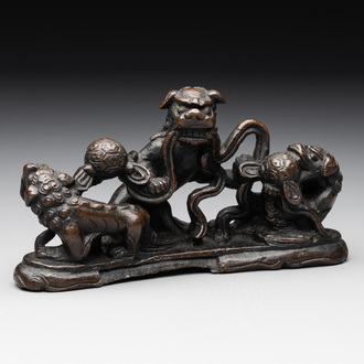 A rare Chinese bronze 'three dancing lions' paperweight or brush rest, Ming