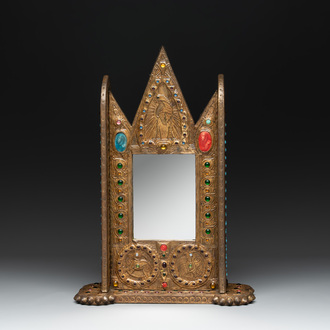 Alfred Daguet (Paris, 1875-1942): A Gothic Revival repoussé brass and copper-mounted mirror with glass cabochons, signed and dated 1907