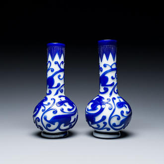 A pair of Chinese blue-overlay white Beijing glass 'chilong' bottle vases, 19th C.