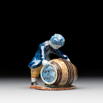 A polychrome Dutch Delft model of a boy rolling a 'wijn azijn' barrel, 18th C.
