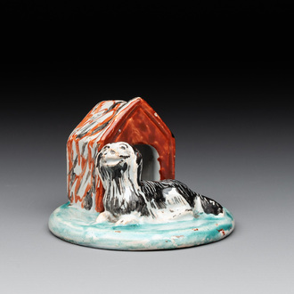 A rare polychrome Dutch Delft group of a dog in front of its doghouse, 18th C.
