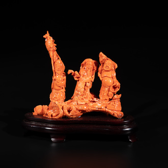A Chinese red coral 'Sanxing' group on wooden stand, 19/20th C.