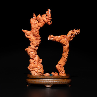 A Chinese pink-orange coral group of a goddess of spring, a wise man and children in a pine tree, 19/20th C.