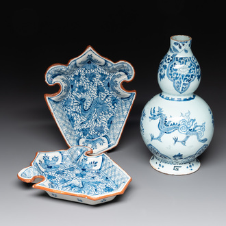 A pair of blue and white Dutch Delft fleur-de-lys-shaped 'Chinese dragon' dishes and a double gourd vase, 17/18th C.