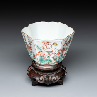A fine Chinese famille verte 'boy and lotus' flower-shaped cup and a wooden stand, Kangxi