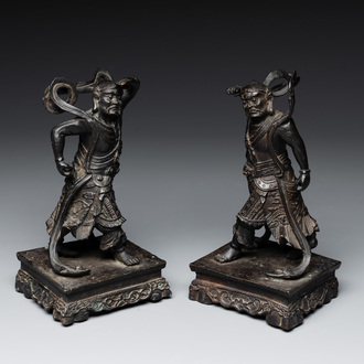 A pair of Chinese bronze guardians on stands, 17/18th C.