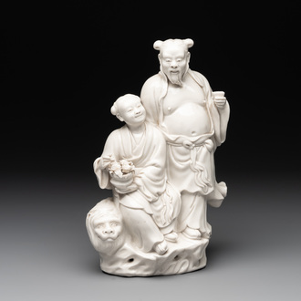 A Chinese Dehua blanc de Chine group of a man and a seated boy on a lion, 20th C.