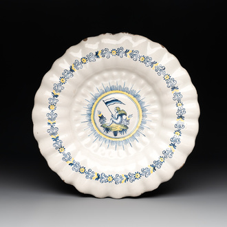 A Dutch Delft or Haarlem blue, white and yellow gadrooned dish with a putto, 17th C.