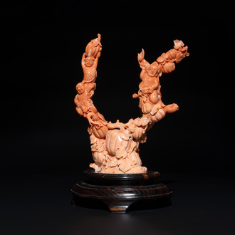 A Chinese red coral group of boys and bitter gourds on wooden stand, 19/20th C.