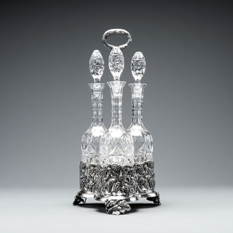 A sterling silver tantalus with three crystal-cut bottles and stoppers, 19/20th C.