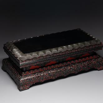 A Chinese rectangular carved red and black lacquer stand, 20th C.