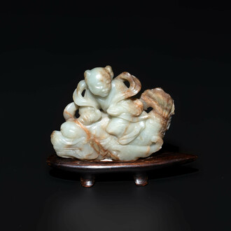 A Chinese celadon and russet jade figure of a boy riding a dragon carp, Qing