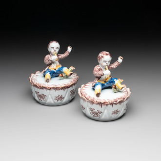 A pair of polychrome Dutch Delft fluting-children-topped butter tubs and covers, 18th C.
