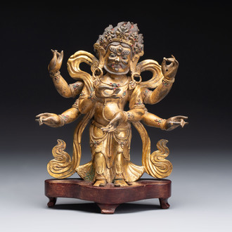 A Sino-Tibetan gilt-bronze figure of White Mahakala on wooden stand, 18th C.