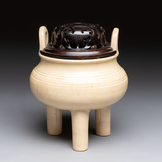 A Chinese Swatow cream-glazed tripod censer with wooden cover, 18/19th C.
