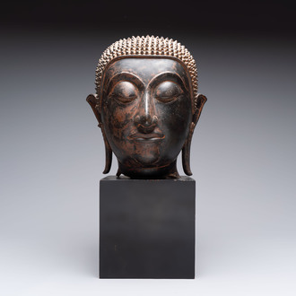 A large Thai bronze Shakyamuni Buddha head on wooden stand, Chieng Sen period, 16th C.