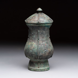 A Chinese archaic bronze food vessel and cover with taotie design, 'zhi 觶', Shang