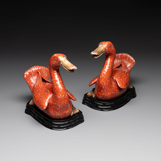 A pair of Chinese partly gilt coral-red-glazed models of ducks on wooden stands, 20th C.