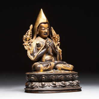 A Tibetan parcel-gilt bronze sculpture of a lama, 20th C.