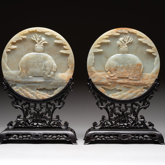 A pair of Chinese carved jade ‘elephant’ plaques on wooden stands, 19th C.