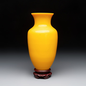 A Chinese Peking yellow glass vase on wooden stand, 19th C.
