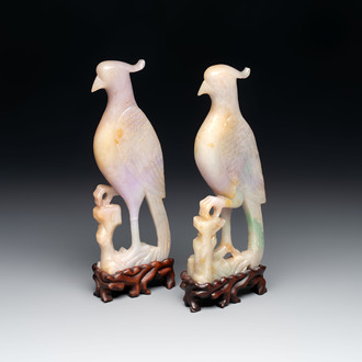 A pair of Chinese lavender and emerald-green jadeite parrots on wooden stands, 19th C.