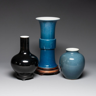 A Chinese black-glazed bottle vase, a blue-glazed jar and a powder-blue 'gu' vase on a wooden stand, Qianlong mark, 19/20th C.