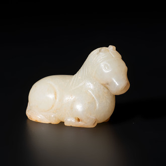 A Chinese white and russet jade pendant in the form of a horse, Song/Ming