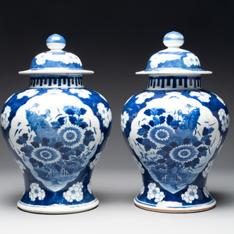 A pair of Chinese blue and white covered vases with floral design, 19th C.