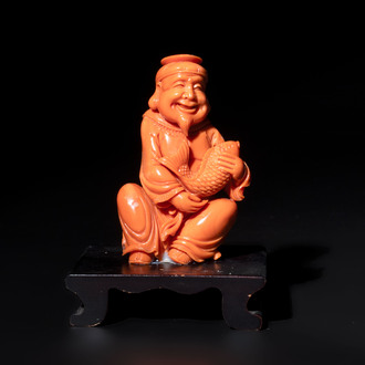 A Japanese red coral sculpture of a fisherman on wooden stand, 19/20th C.