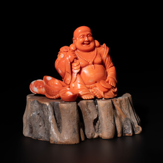 A Chinese red coral sculpture of a Milefo Buddha on wooden stand, 19/20th C.