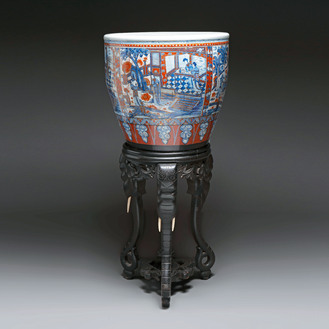 A large Chinese European-decorated blue and white fish bowl with narrative design, on a later wooden stand, Kangxi