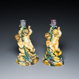 A pair of polychrome Spanish pottery candlesticks with putti on a branch, Talavera, 18th C.