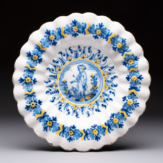 A polychrome lobed Dutch Delft 'Compendario' dish with a shepherd with his dog, 17th C.