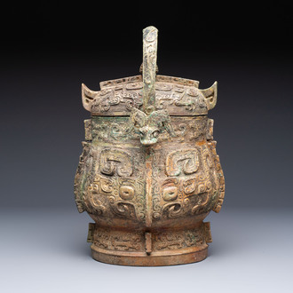 A Chinese archaic bronze wine vessel and cover with Taotie design, You 卣, late Shang