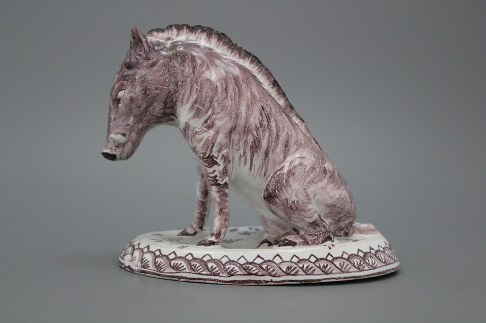 A Dutch Delft manganese faience model of a wild boar, marked AP