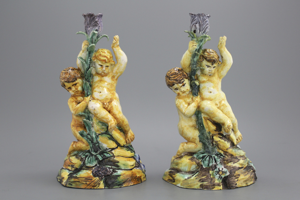 A pair of Spanish Talavera candlesticks with putti on a branch, 18th C.