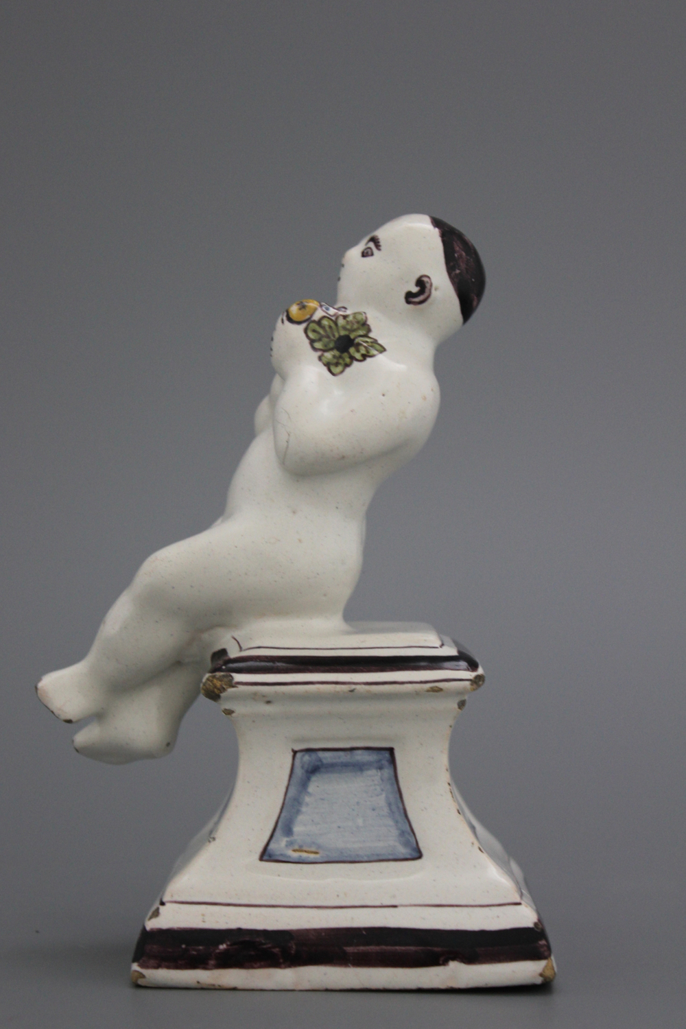 A French ceramic figure of a boy on a base, 18th C.