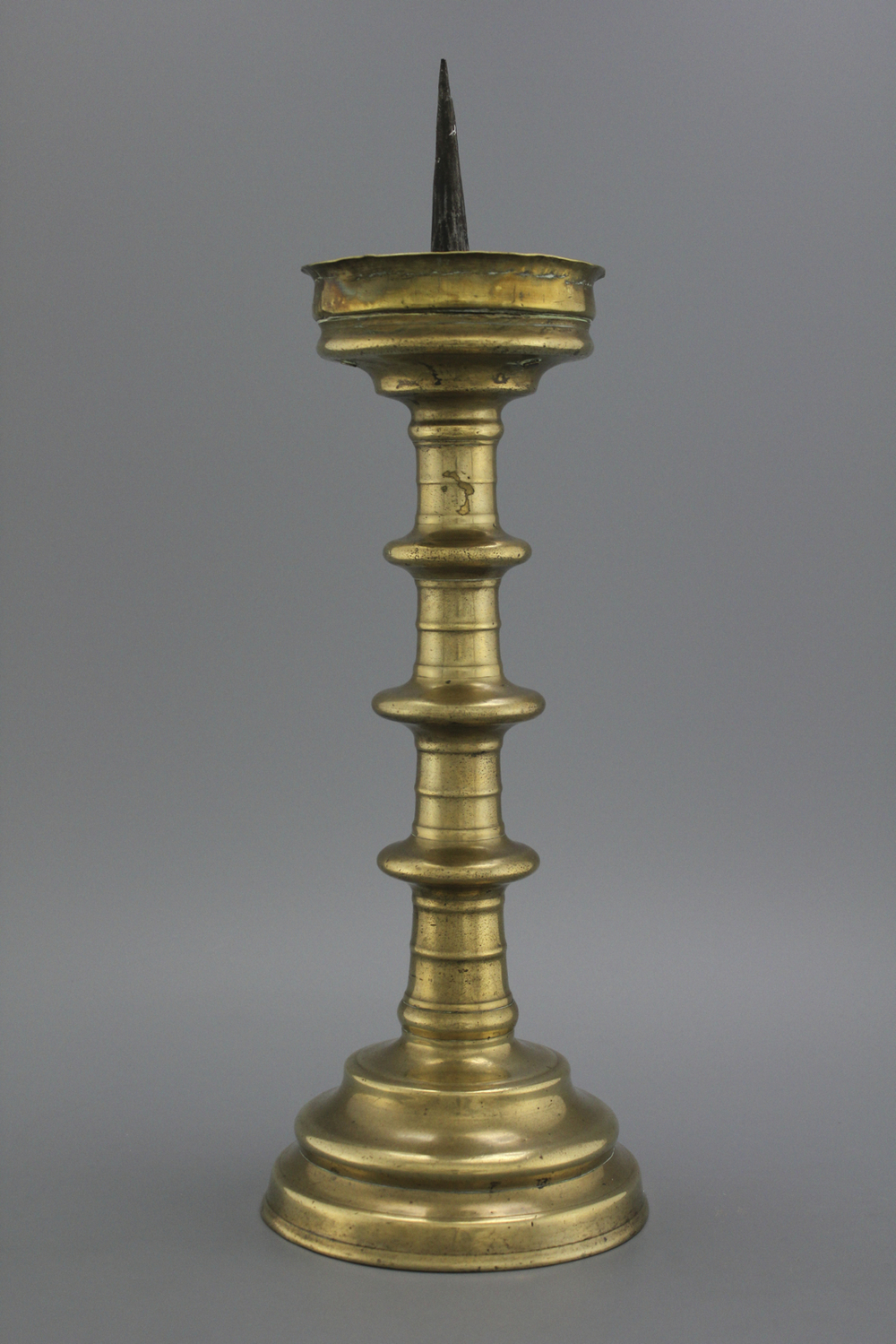 A large brass pricket candlestick, 16th C.