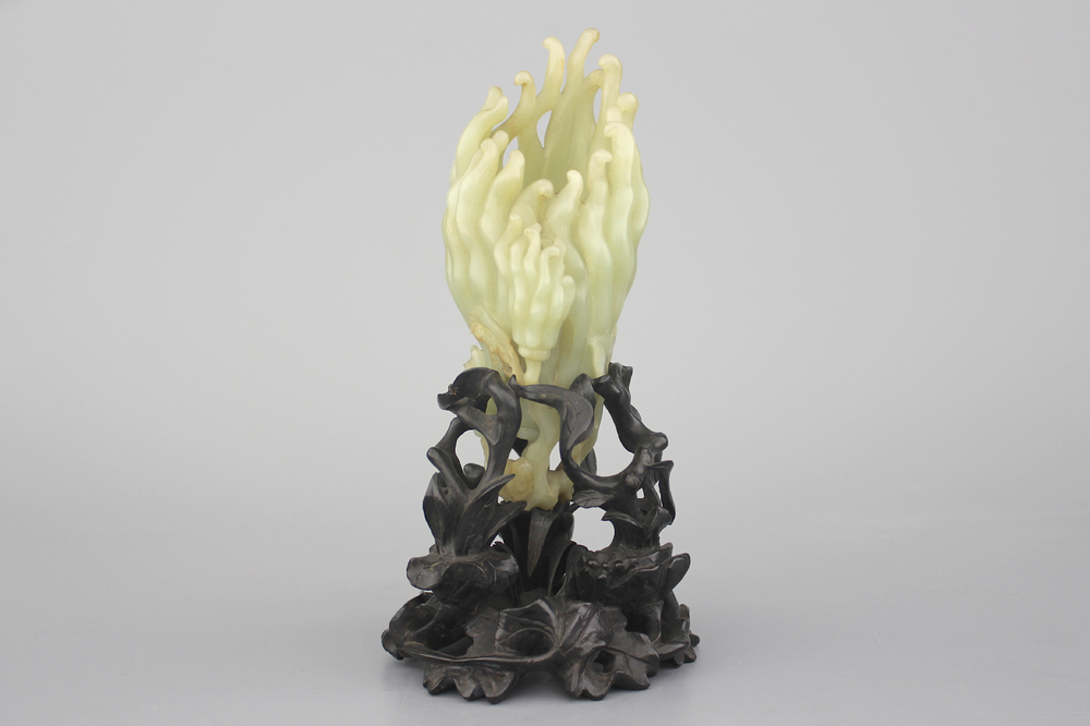 A jade buddha hand on a carved wood stand, Qing dynasty, 18th C.