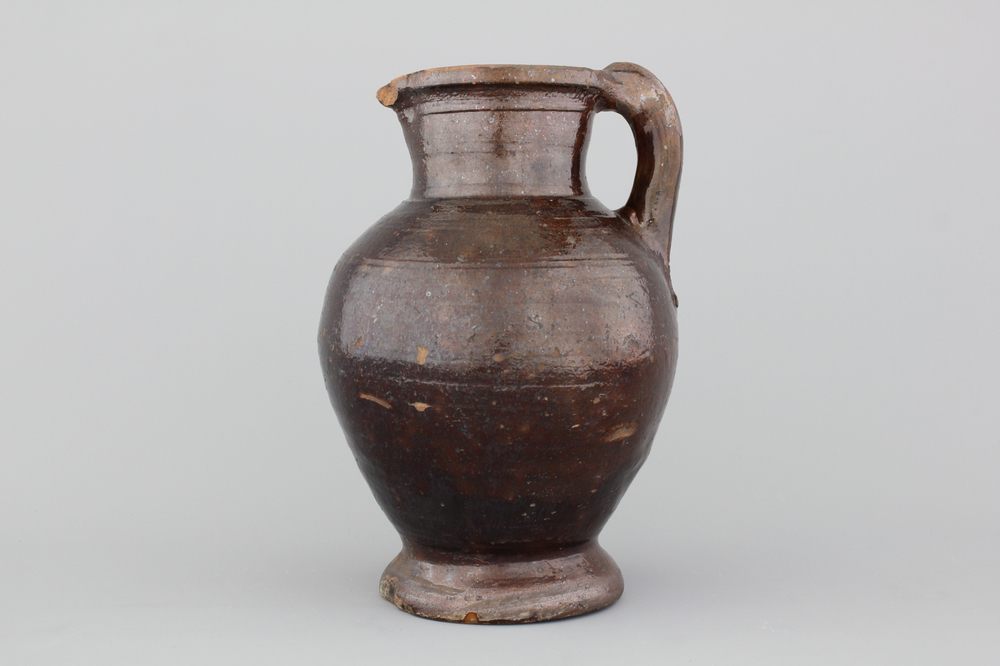 A brown-glazed terra cotta jug, Low Countries, 17th C.