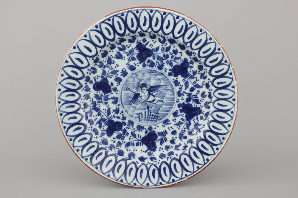 A Dutch Delft blue and white plate with a putto, 18th C.