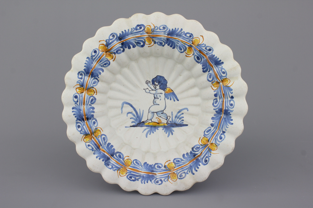 A Nevers fluted polychrome &quot;compendario&quot; dish with a putto, 17th C.