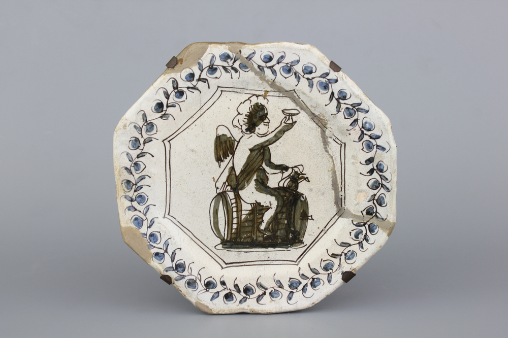 A rare Dutch Haarlem maiolica plate with Bacchus on a barrel, 17th C.