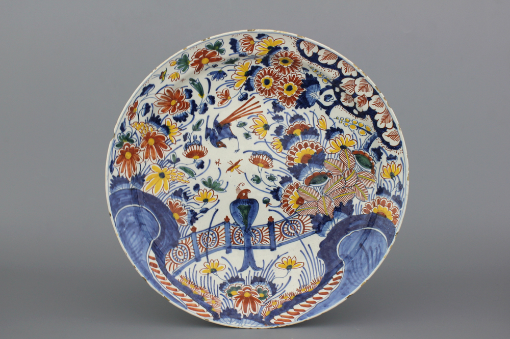 A Dutch Delft polychrome chinoiserie dish with a bird on a fence, early 18th C.