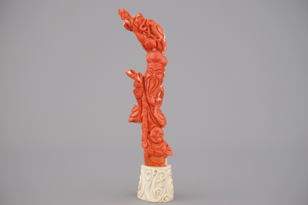 An unusual Chinese carved coral figure of Shou Lao on an ivory stand, Qing Dynasty